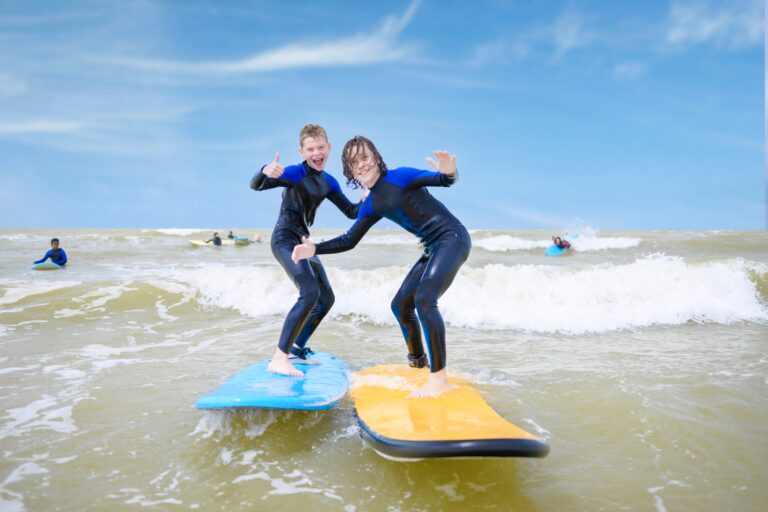 2 jongens surfen naast elkaar en nemen golf